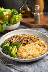 Breaded fried fish with lettuce salad and vegetable salad.