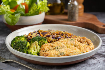 Breaded fried fish with lettuce salad and vegetable salad.