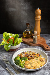 Breaded fried fish with lettuce salad and vegetable salad.
