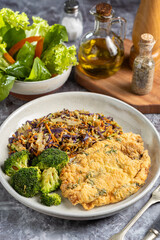Breaded fried fish with lettuce salad and vegetable salad.