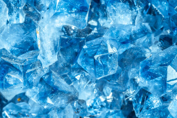 Obraz premium Blue Crystal Mineral Stone. Gems. Mineral crystals in the natural environment. Texture of precious and semiprecious stones. Seamless background with copy space colored shiny surface of precious stones