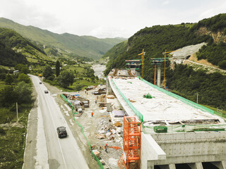 Kazbegi, Georgia - 7th july, 2024: aerial view cranes and bridge foundation pillars on construction...