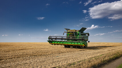 The combine is on the horizon. Harvesting wheat in modern conditions. It's time to harvest.
