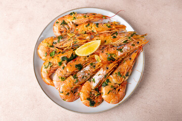 Langoustines fried in butter with garlic and parsley. Served with a slice of lemon. Traditional Mediterranean cuisine. A popular appetizer in restaurants and pubs. Homemade cooking. Selective focus.