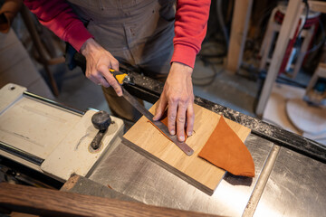 Man hands cutting leather skin. Master shoemaker pro cobbler guy palms measures right amount, uses...