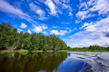 Naklejka premium Beautiful summer river at sunny day with clouds reflection in the water