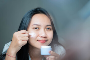 Woman applying face cream