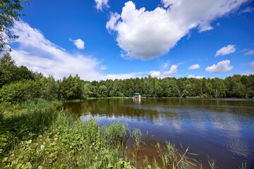 A small wooden house with boats by the riverbank
