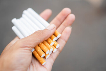 Hand holding multiple cigarettes