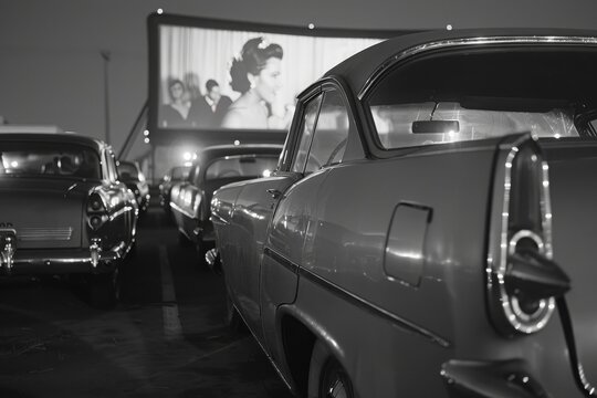Vintage Cars Parked at a Drive-In Movie Theater at Night