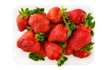 Red strawberries ugly with green stems and water drops in plastic container isolated on white background. Supermarket plastic box container with fresh sweet fruits. Delivery of ugly products concept.