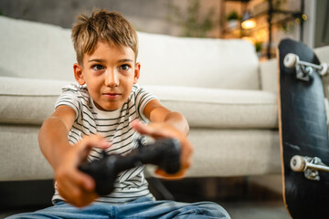 young boy sit on the floor and play video games on joystick at home © Miljan Živković