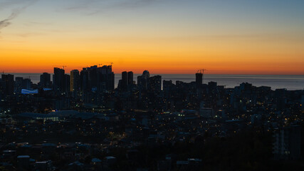 Panoramic view of Batumi with lights and the sea from the top of the cable car on the mountain at dusk at sunset. Stunning view of the city of Batumi.
