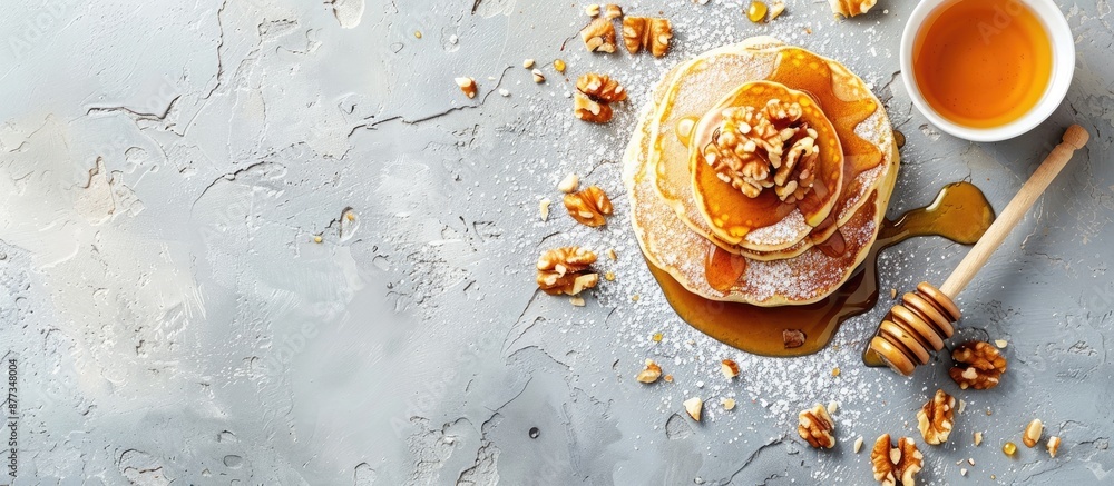 Poster top down view of homemade pancakes adorned with nuts and honey on a textured gray surface for pancak