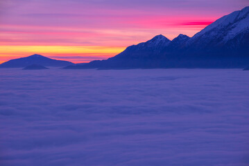 Aerial View over Cloudscape and Snow Capped Mountain in Sunset with Colorful sky in Locarno, Ticino, Switzerland.
