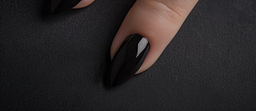 Nail painted black on black paper provides a sleek example of a copy space image