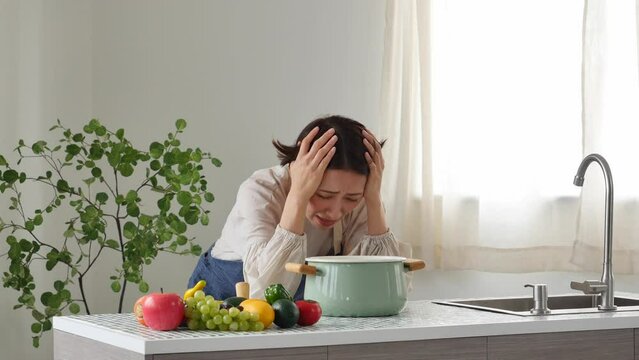 キッチンで落ち込む女性