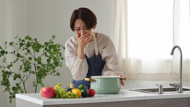 キッチンで吐き気がする女性