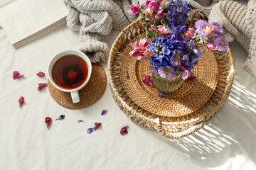 Still life with a cup of tea and a bouquet of wildflowers in a home interior.