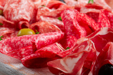 Assorted, meat appetizer, prosciutto, salami and ham, with olives , close-up, breakfast, top view, close-up, without people