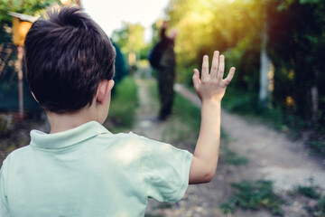 A young soldier watches his son before leaving for an overseas assignment. A boy waves to his soldier father as he sends him off to the army.
