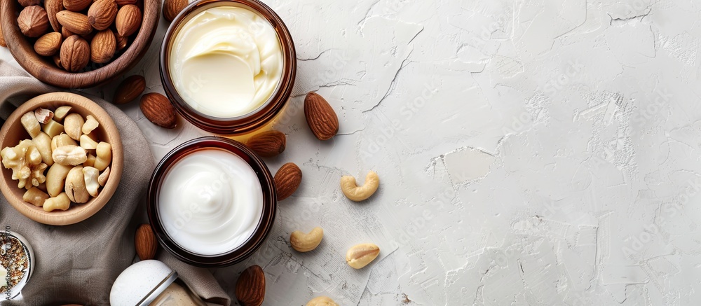 Poster argan and macadamia oil creme shampoo and nuts displayed on a white background with copy space image