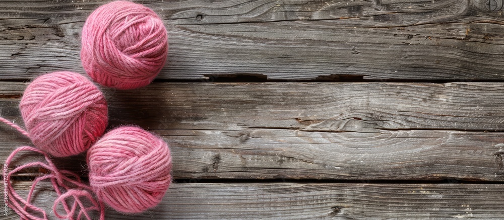 Poster pink balls of wool resting on an aged wooden surface with ample copy space image available