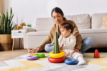 A young Asian mother joyfully plays with her little son on the floor of their living room.