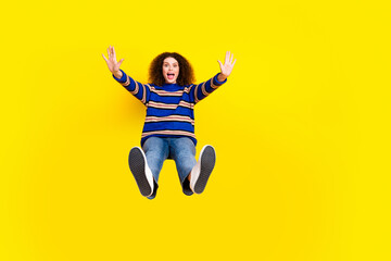 Obraz premium Full length photo of astonished girl dressed knit sweater falling from platform raising palms scream isolated on yellow color background