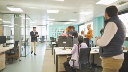 Obraz premium Office employees celebrating a work achievement with hugs and applause.