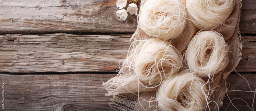 Poster top down view of raw rice noodles on wooden surface with a napkin ideal for adding text in the copy 