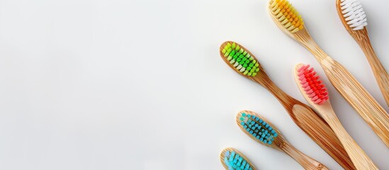 Multicolored toothbrushes made out of bamboo with varying colors rest on a white background providing a visually appealing oral care copy space image