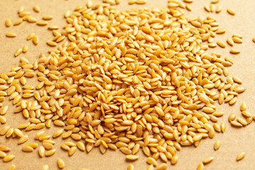 Many linseeds on brown background. Golden healthy flax seeds