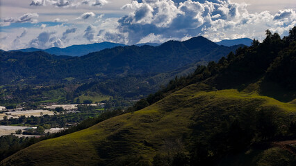 Naklejka premium Foto aérea en zona rural del municipio de La Ceja, Antioquia, Colombia. Se disfruta del hermoso contraste entre el verde de sus montañas y el cielo azul