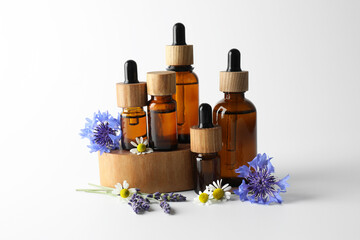 Aromatherapy. Different essential oils and flowers on white background