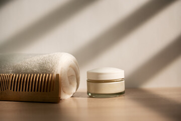 White towel, wooden comb, glass bottle. In the bathroom.