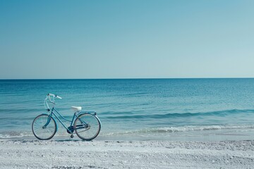 Blue bicycle is standing on a white sand beach with a turquoise sea and clear sky background, conveying a sense of freedom and adventure