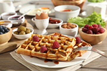 Different meals served for breakfast on wooden table