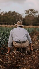 Farmer Kneeling in Field