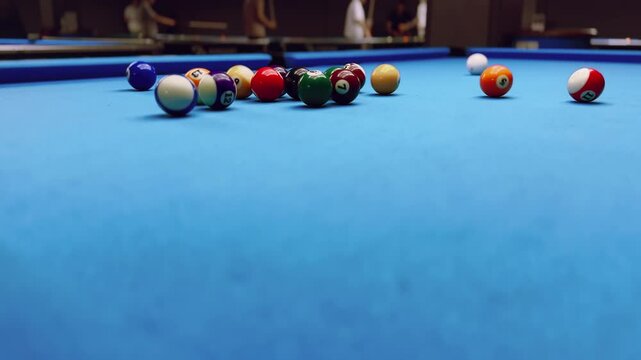 Middle shot. Woman breaking racked pool balls in eight-ball on billiard table