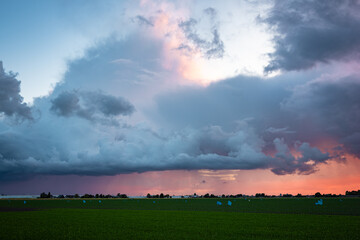 Beautiful view of a thundery shower, illuminated purple by the setting sun