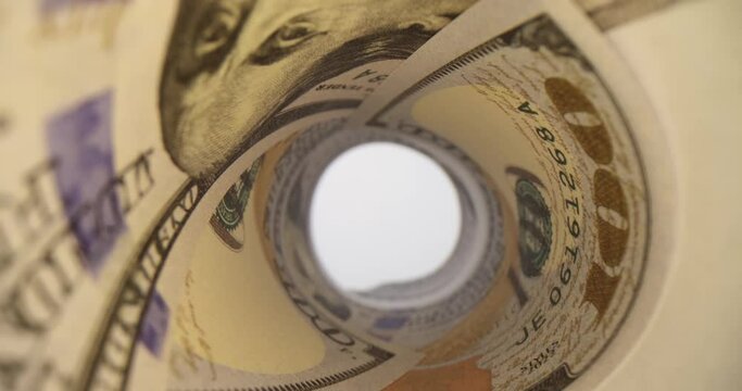 Twisted in pipe dollars with various denominations. Long money funnel with bright light spreading through narrow hole and illuminating banknotes