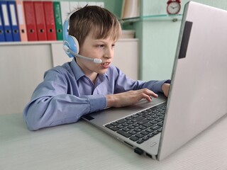 Young Boy Using Laptop With Headset During Online Class in Home Office