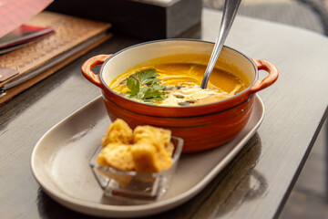 Pumpkin cream soup in bowl. Soup and croutons in the restaurant