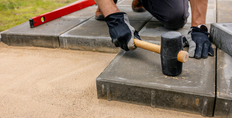 man laying concrete paving slabs for patio