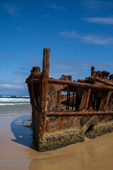 Old shipwreck on the beach with the ocean behind