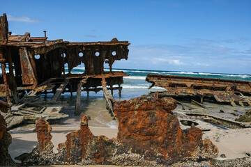 Old shipwreck on the beach with the ocean behind