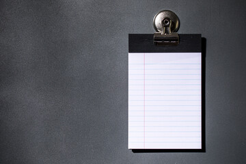 Lined note paper on dark gray magnet board