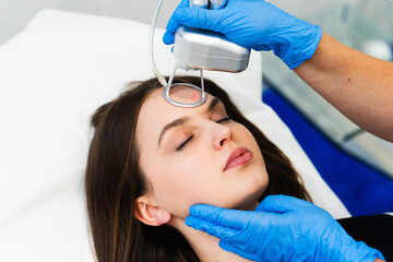Process of facial CO2 laser resurfacing. Cosmetologist removes wrinkles and scars using laser from...
