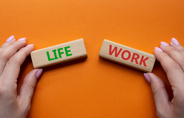 Life or Work symbol. Concept word Life or Work on wooden blocks. Businessman hand. Beautiful orange background. Business and Life or Work concept. Copy space